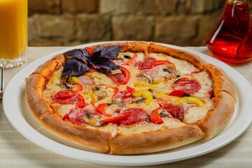 Fresh hot pizza on white plate in restaurant.
