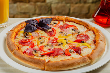 Fresh hot pizza on white plate in restaurant.