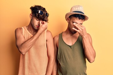 Young gay couple wearing summer clothes tired rubbing nose and eyes feeling fatigue and headache....