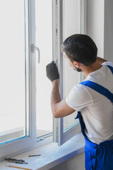 Fototapeta na wymiar Worker in overalls preparing to install a window