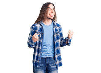 Young adult man with long hair wearing casual shirt excited for success with arms raised and eyes closed celebrating victory smiling. winner concept.