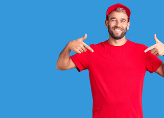 Young handsome blond man wearing t-shirt and cap looking confident with smile on face, pointing oneself with fingers proud and happy.