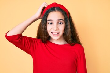 Cute hispanic child girl wearing casual clothes and diadem confuse and wonder about question. uncertain with doubt, thinking with hand on head. pensive concept.