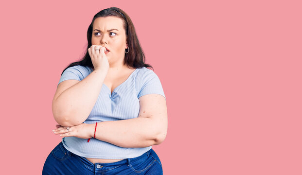 Young plus size woman wearing casual clothes looking stressed and nervous with hands on mouth biting nails. anxiety problem.