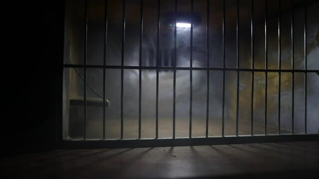 Behind bars concept. Obsolete grunge concrete room miniature. Dark prison interior creative decoration. Empty cell. Selective focus