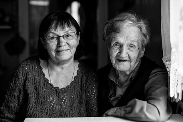 Portrait of Woman at the age with his old mother. Black and white photography.