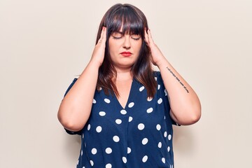 Young plus size woman wearing casual clothes suffering from headache desperate and stressed because pain and migraine. hands on head.