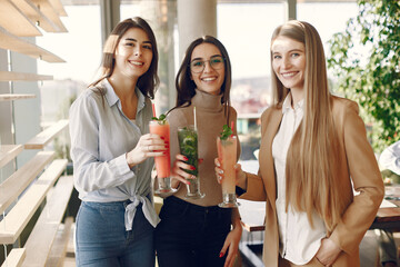 Girls in a cafe. Women drinking a cocktails. Friends talking.