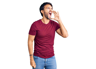 Handsome hispanic man wearing casual clothes shouting and screaming loud to side with hand on mouth. communication concept.