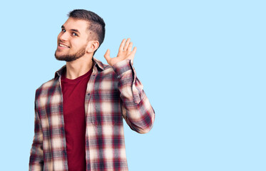 Young handsome man wearing casual shirt waiving saying hello happy and smiling, friendly welcome gesture