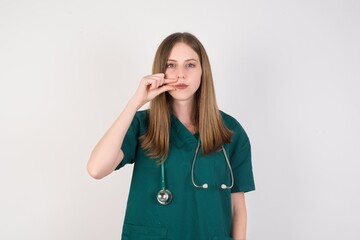Female doctor wearing a green scrubs and stethoscope mouth and lips shut as zip with fingers....