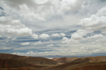 Desert landscape. Aerial view of the brown  arid mountains and valley under a beautiful cloudy sky.