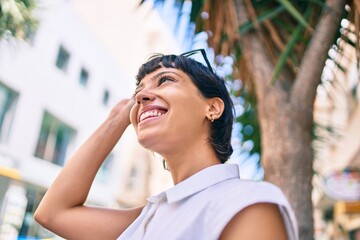 Young woman with short hair smiling happy outdoors