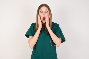 Studio shot of scared terrified Female doctor wearing a green scrubs and stethoscope customer shocked with prices at shop, being short of money to buy something, People and human emotions concept