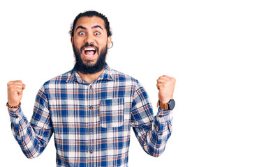 Fototapeta premium Young arab man wearing casual clothes celebrating surprised and amazed for success with arms raised and open eyes. winner concept.