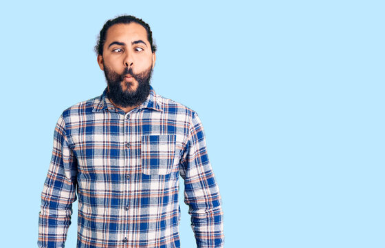 Young arab man wearing casual clothes making fish face with lips, crazy and comical gesture. funny expression.