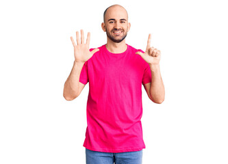 Naklejka premium Young handsome man wearing casual t shirt showing and pointing up with fingers number seven while smiling confident and happy.