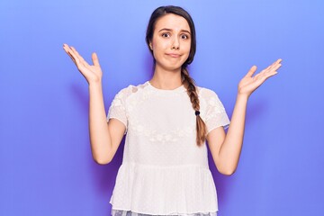 Young beautiful girl wearing casual t-shirt clueless and confused with open arms, no idea and doubtful face.