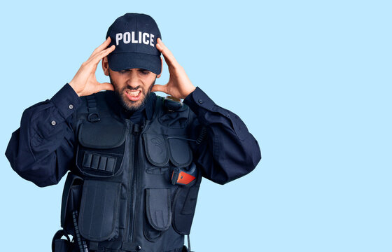 Young handsome man with beard wearing police uniform with hand on head for pain in head because stress. suffering migraine.