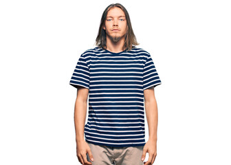 Obraz premium Handsome caucasian man with long hair wearing casual striped t-shirt relaxed with serious expression on face. simple and natural looking at the camera.