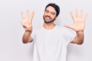 Naklejka premium Young hispanic man wearing casual clothes showing and pointing up with fingers number eight while smiling confident and happy.