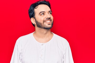 Young hispanic man wearing casual clothes looking to side, relax profile pose with natural face and confident smile.