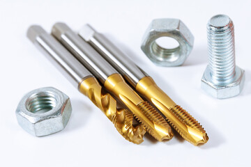 Set of tap for threading in metal. Bolts and nuts isolated on white background. Tool for metal...