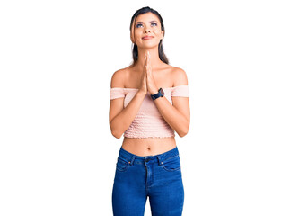 Young beautiful woman wearing casual clothes begging and praying with hands together with hope expression on face very emotional and worried. begging.