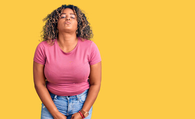 Young african american plus size woman wearing casual clothes looking at the camera blowing a kiss on air being lovely and sexy. love expression.