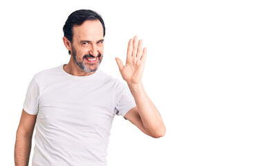 Naklejka premium Middle age handsome man wearing casual t-shirt waiving saying hello happy and smiling, friendly welcome gesture