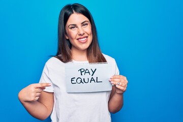 Young beautiful woman asking for gender equality holding paper with pay equal message smiling happy...