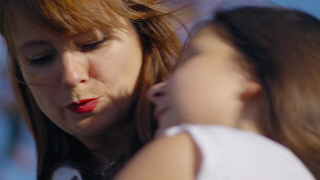 Mom kisses daughter. Love for children
Female hugs baby. 
White-skinned girl touches head and hair
Shot URSA 4.6K