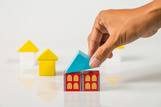 Hand building house (real estate) with wooden blocks