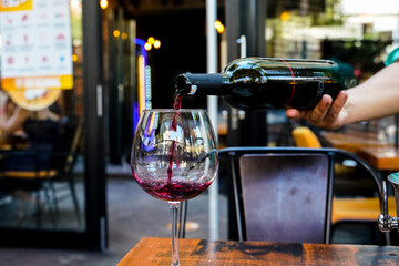 red wine bottle pouring red wine glass service waiter hand