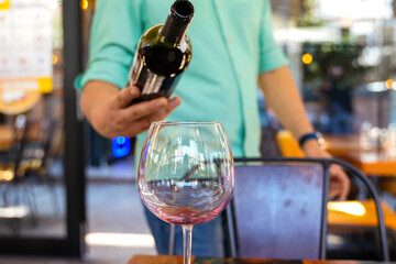 red wine pouring in a wine glass waiter service
