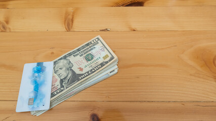 Cash card and dollar money placed on a wooden table.