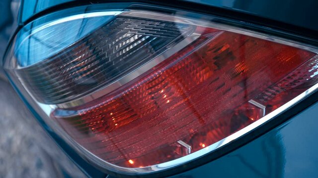 Turning the dimensions in the block of rear lights of a blue car. Closeup