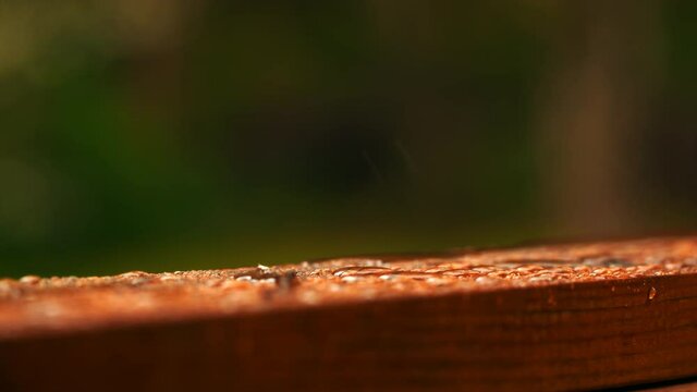 Rain hitting the wooden railing in 6K.