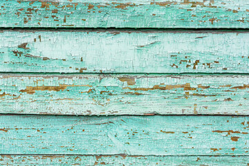 The surface of an old light green, cracked wood plank as a texture. The boards are laid horizontally.