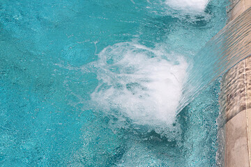 Close up blue water splash in swimming pool