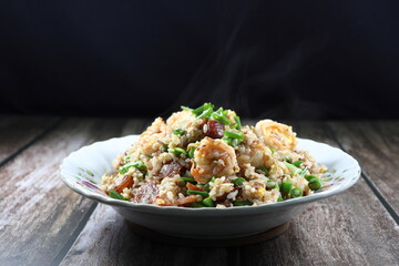 Traditional fried and stirred cooked rice with cutting green bean, fresh peeled shrimp and chopped pork sausage on the plate. Famous special breakfast in the morning in Asia.