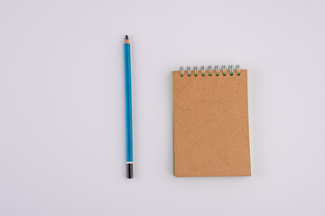 Pencil and brown notebook isolated on white background