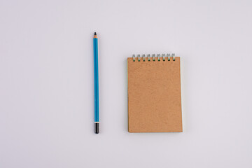 Pencil and brown notebook isolated on white background
