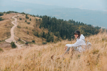 Fototapeta na wymiar woman sitting on the ground looking at mountains hiking concept