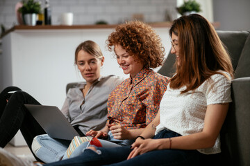 Happy businesswomen talking and laughing in office. Beautiful women drinking coffee in the office..