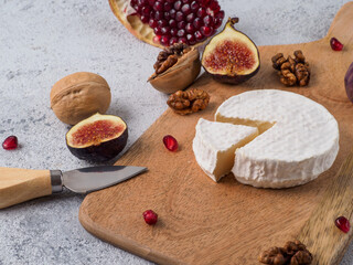 Traditional french cheese brie on wodden cutting board.