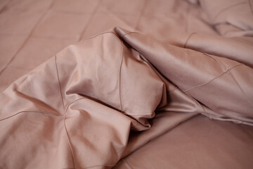 Unmade empty bed. Beige bed linen