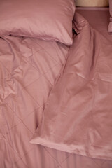 Unmade empty bed. Beige bed linen