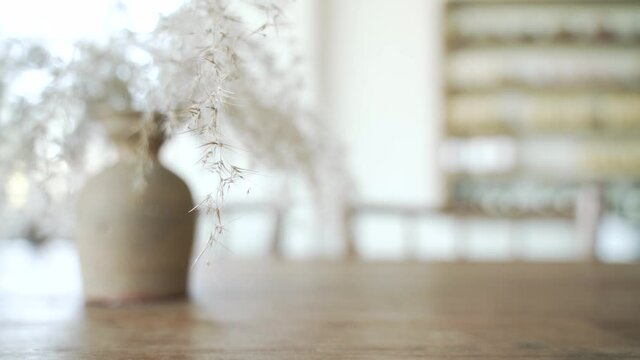 Wooden table at the cafe with beautiful dry grass Poaceae wild spike savanna flower decoration