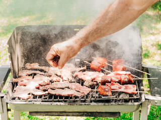 Man adding salt to barbecued meat
